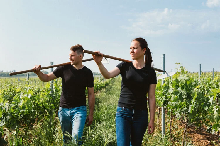 Bianka und Daniel Schmitt mit Werkzeug im Weingarten